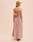A dusty pink floral maxi dress with a v-neckline and a small slit at the bottom.