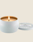 A white mini tin single wick candle with the name of the candle 'Voluspa Bourbon Vanille' on the lid.