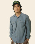 A blue flannel material button up shirt for men with long sleeves and two front pockets.