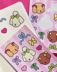 A sticker sheet with dog characters from Bobbie Good with bows on.