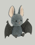 A grey bat shaped stuffed animal toy.