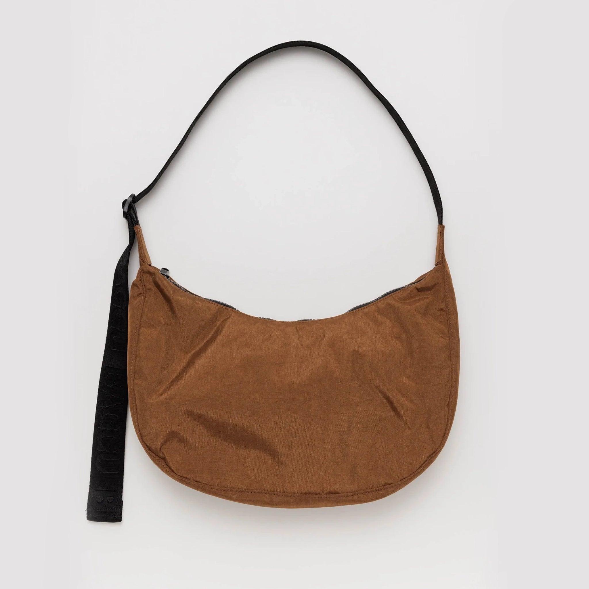 On a white background is a brown nylon bag with a black adjustable strap. 