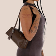 A small recycled brown leather handbag with shoulder straps.