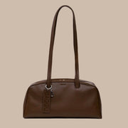 A chocolate brown recycled leather handbag with shoulder straps.
