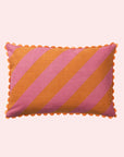 A pink and orange striped pillow with a smaller stripe on the other side and a scalloped edge.