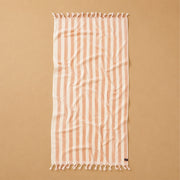 Striped towel with tassels on a beige background