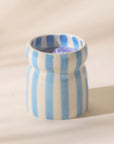 A blue and cream striped ceramic candle.