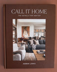 On a brown background is a brown book cover with a photo of a curated interior design space with white text at the top that reads, "Call It Home The Details That Matter".