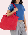 A red nylon carry on tote bag with two handles and a zipper top.