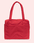 A red small carry on tote bag with two handle straps, front pockets and a zipper closure.
