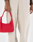 A red nylon shoulder bag with an adjustable strap.