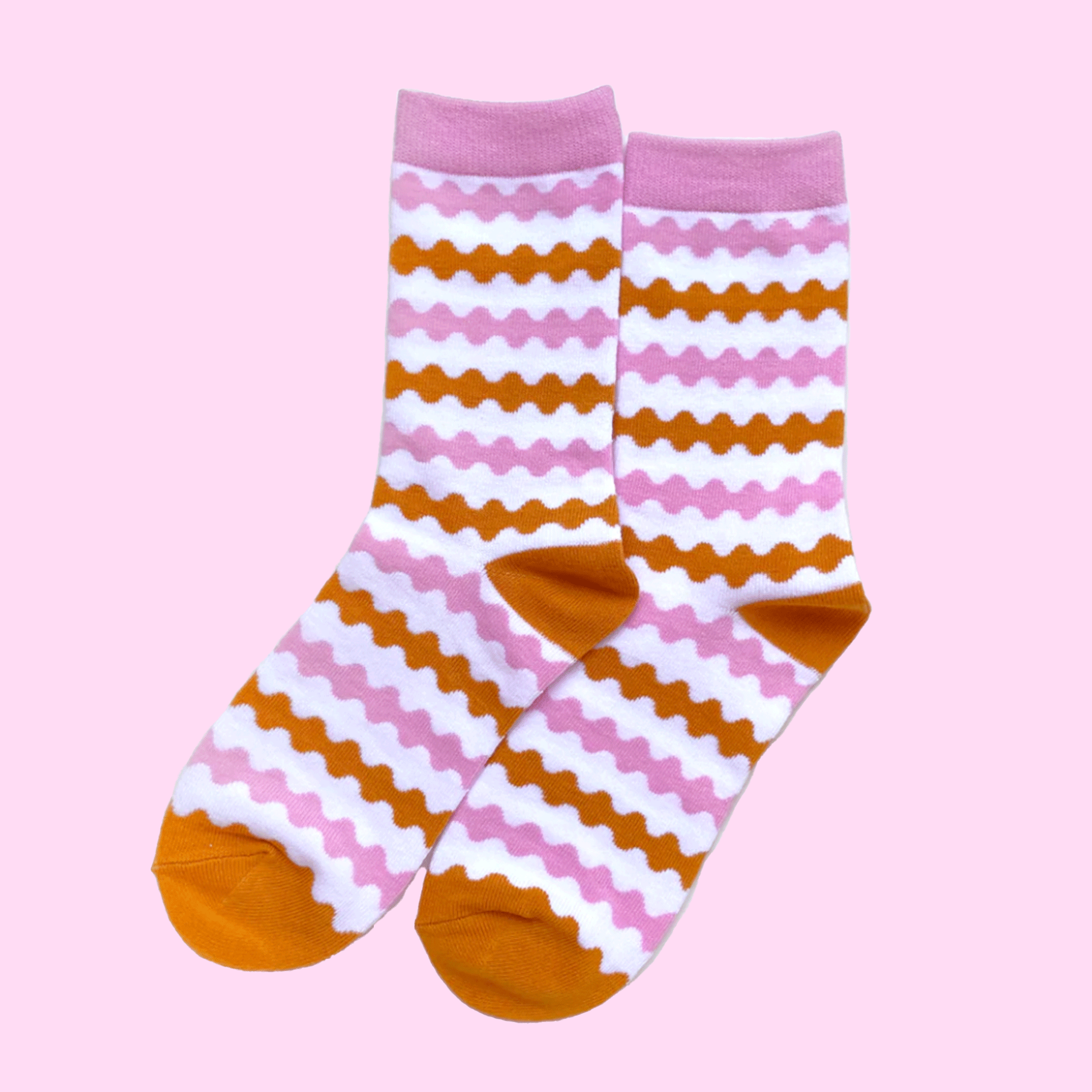 On a pink background is pink and orange striped socks.