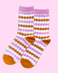On a pink background is pink and orange striped socks.