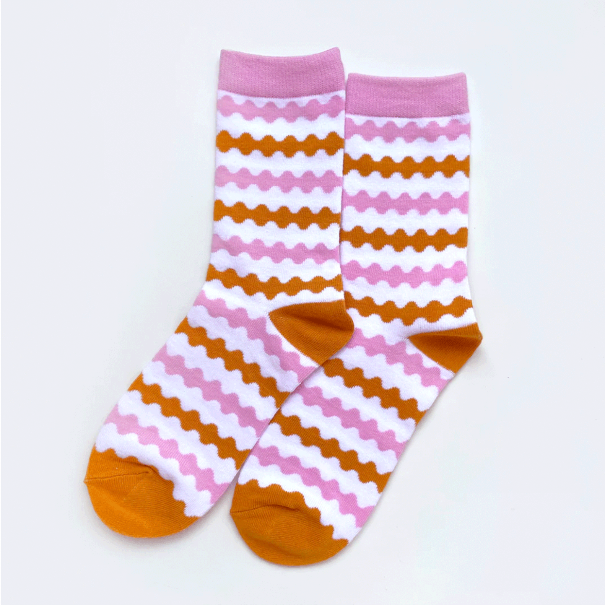 On a white background is pink and orange striped socks. 