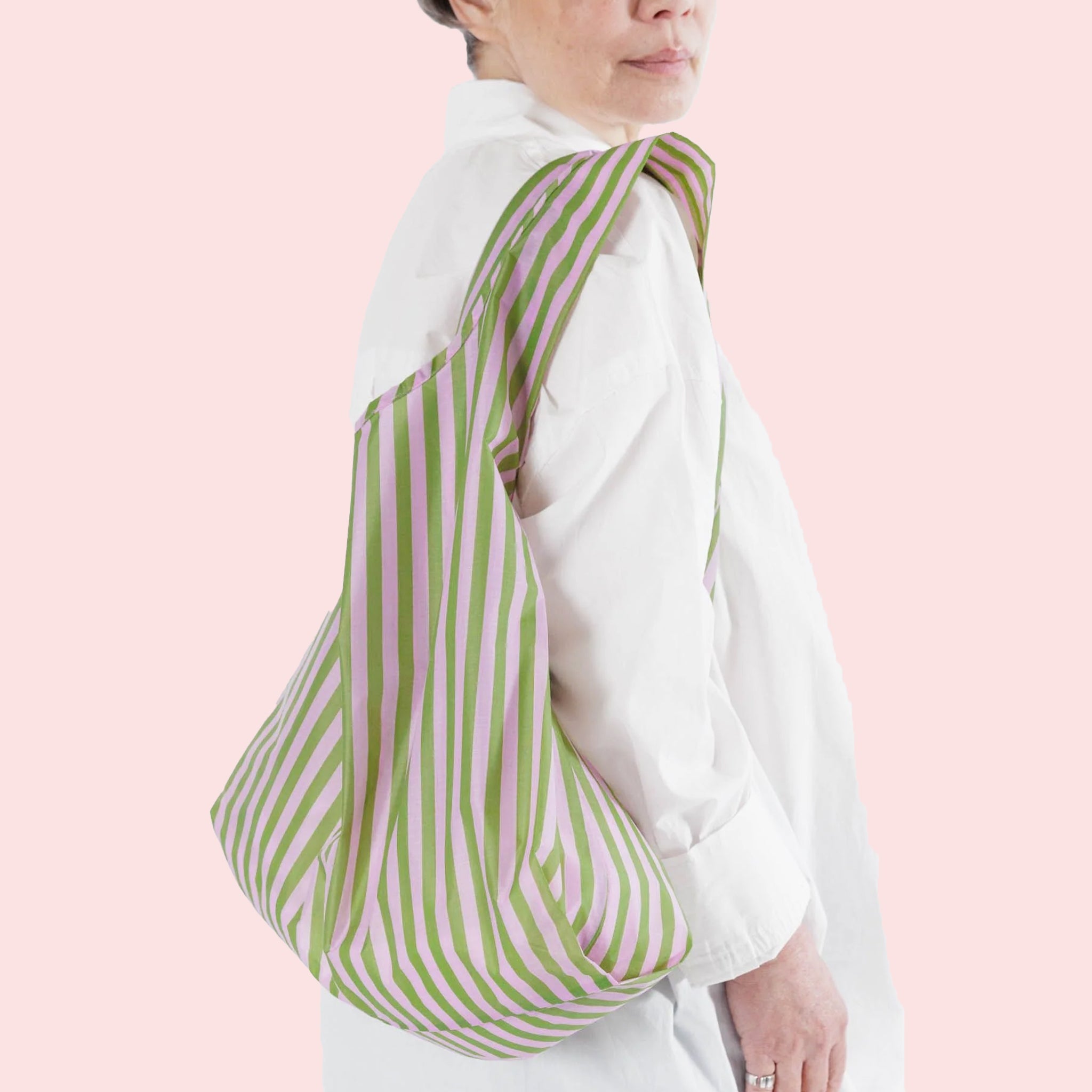 A light pink and green striped nylon reusable tote bag.