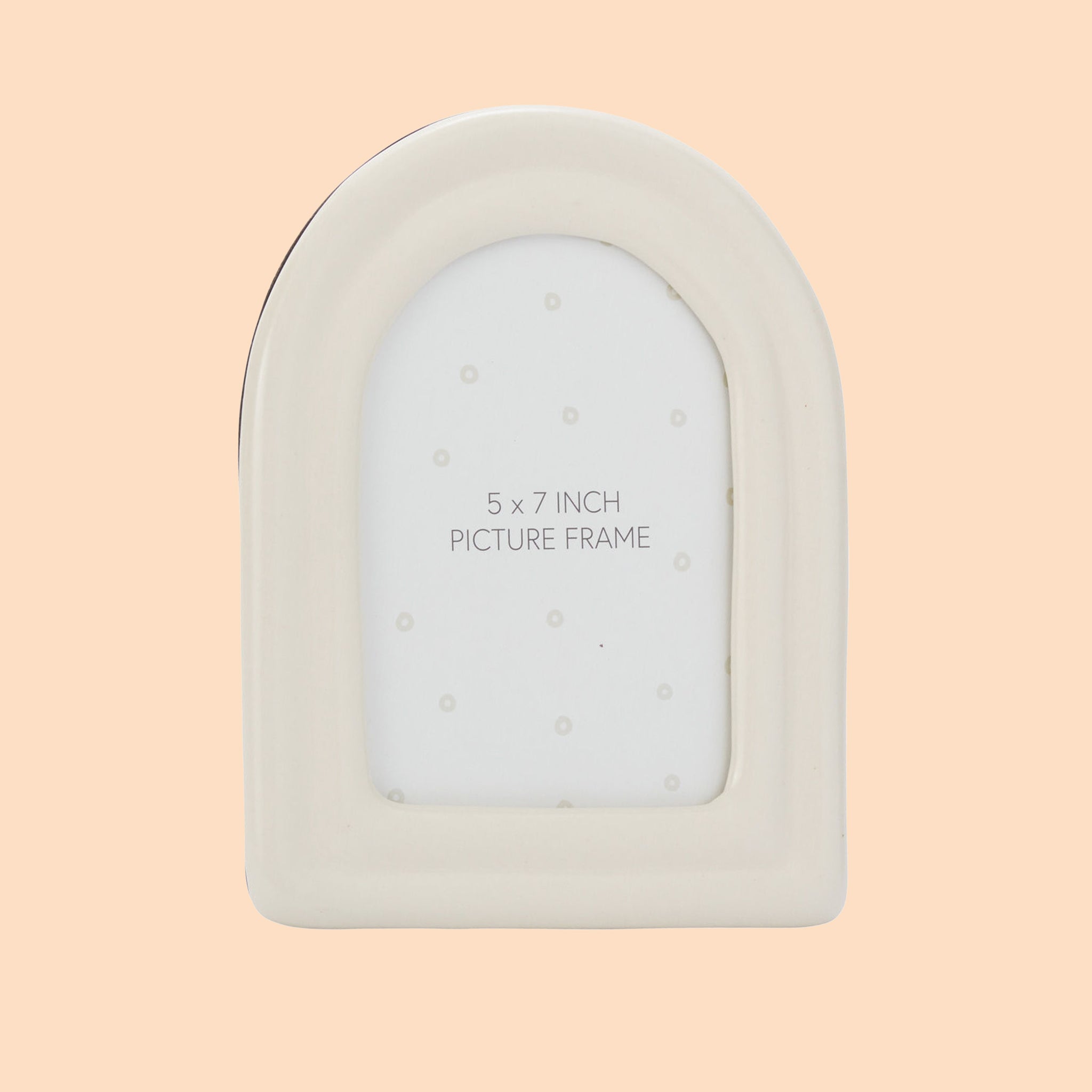 On a peachy background is a white arched ceramic frame. 