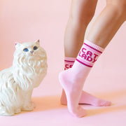 A pair of pink socks with dark pink text on the ankle of the sock that reads, 'Cat Lady'.
