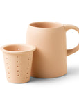 On a white background is a ceramic mug with an infuser cup to insert inside the rim of the mug.