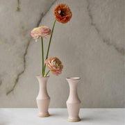 A light pink ceramic bud vase.
