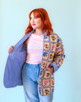 A multi colored quilted jacket with a floral print on one side and a blue solid color on the other.