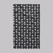 A black towel with white skull and crossbones and pumpkin pattern.