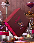 A burgundy tin with a puzzle in. The theme of the puzzle is an assortment of chocolate goods.