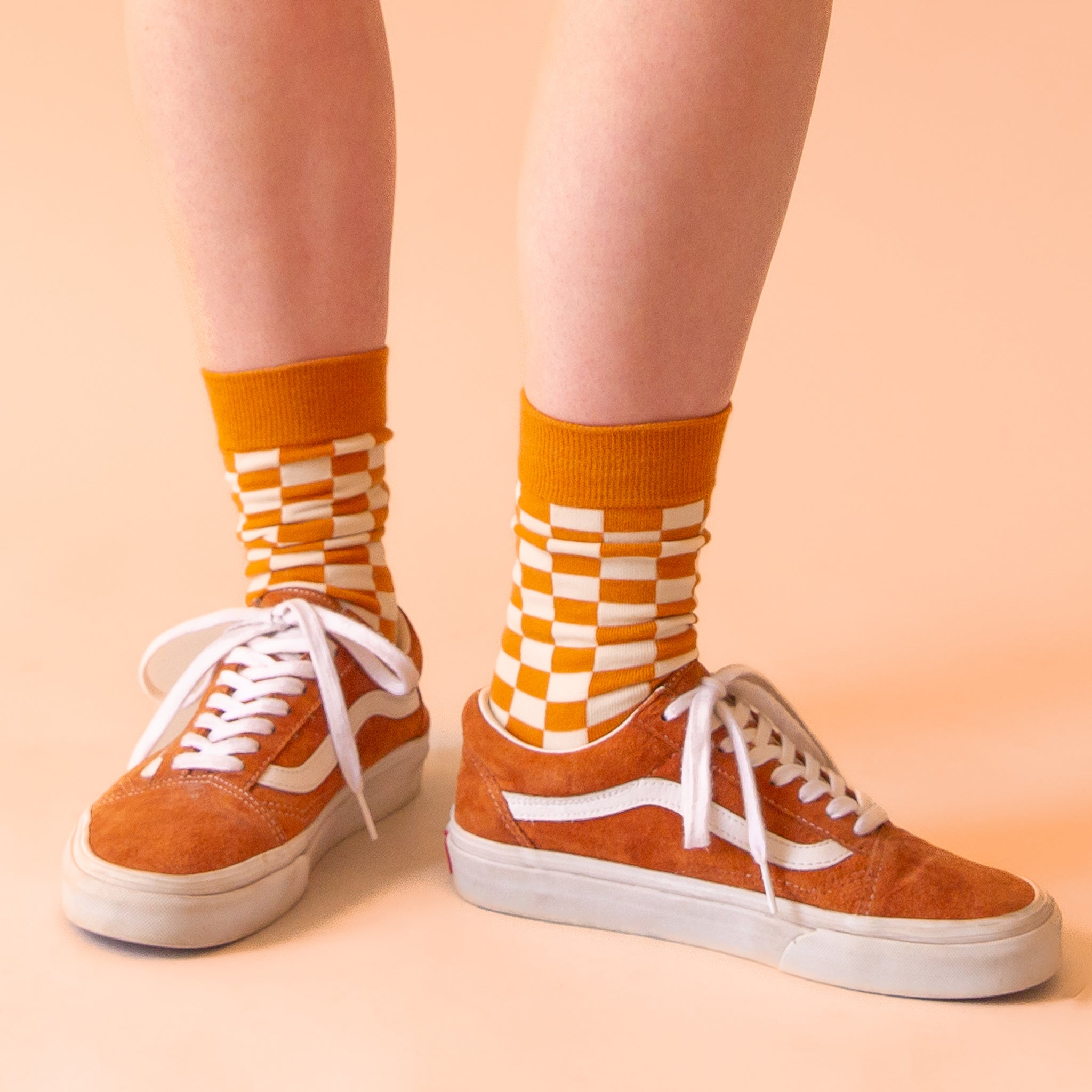 A burnt orange and white checker print pair of socks.