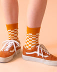 A burnt orange and white checker print pair of socks.