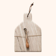 On an ivory background is a tan marble cutting board and knife tied to the center.