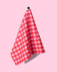 A red and pink gingham print tea towel with a waffle weave.
