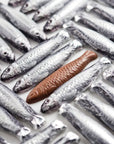 A blue net of chocolates wrapped in silver foil to look like sardine fish.