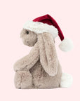 A beige bunny shaped stuffed animal with a red Santa hat.
