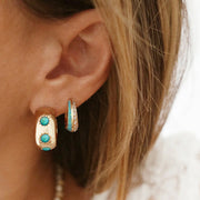 Chunky gold hoop earrings with three blue opal stones.