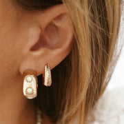 A pair of chunky gold hoops with three white opal stones.