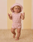A pink kids sleeveless jumpsuit with a pink seashell pattern.