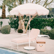 A wavy umbrella base in an antique white color holding an umbrella sold separately.