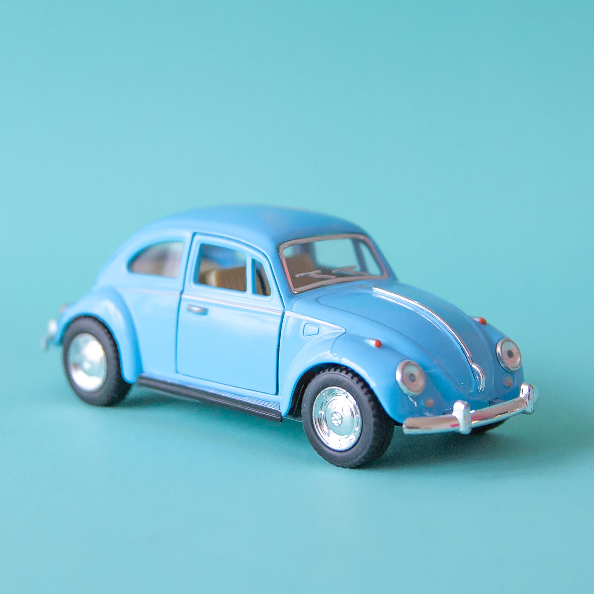 On a blue background is a blue VW beetle toy car.