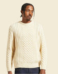 A neutral cable knit sweater in an oatmeal shade.