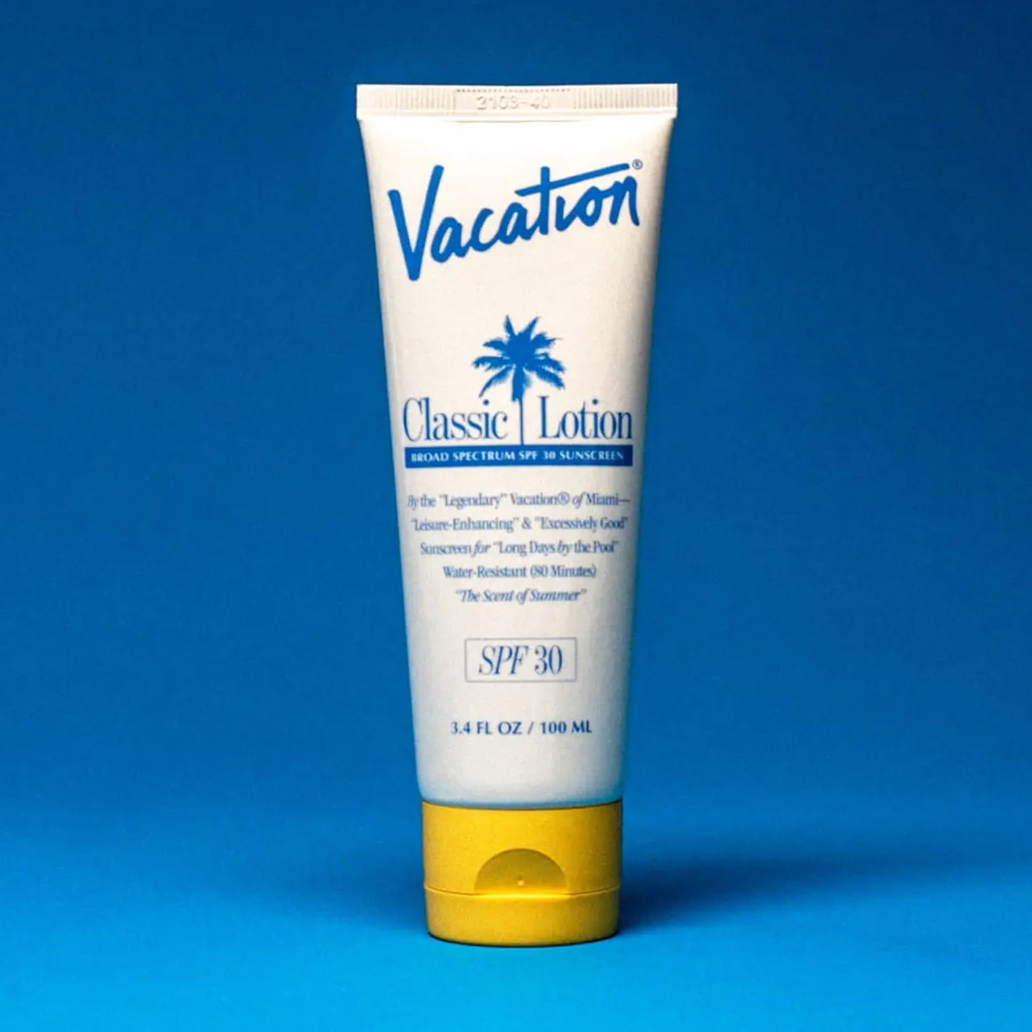 On a blue background is a white squeeze tube of sunscreen with a yellow lid and a blue text that reads, &quot;Vacation Classic Lotion SPF 30&quot; along with a blue palm design in the center.