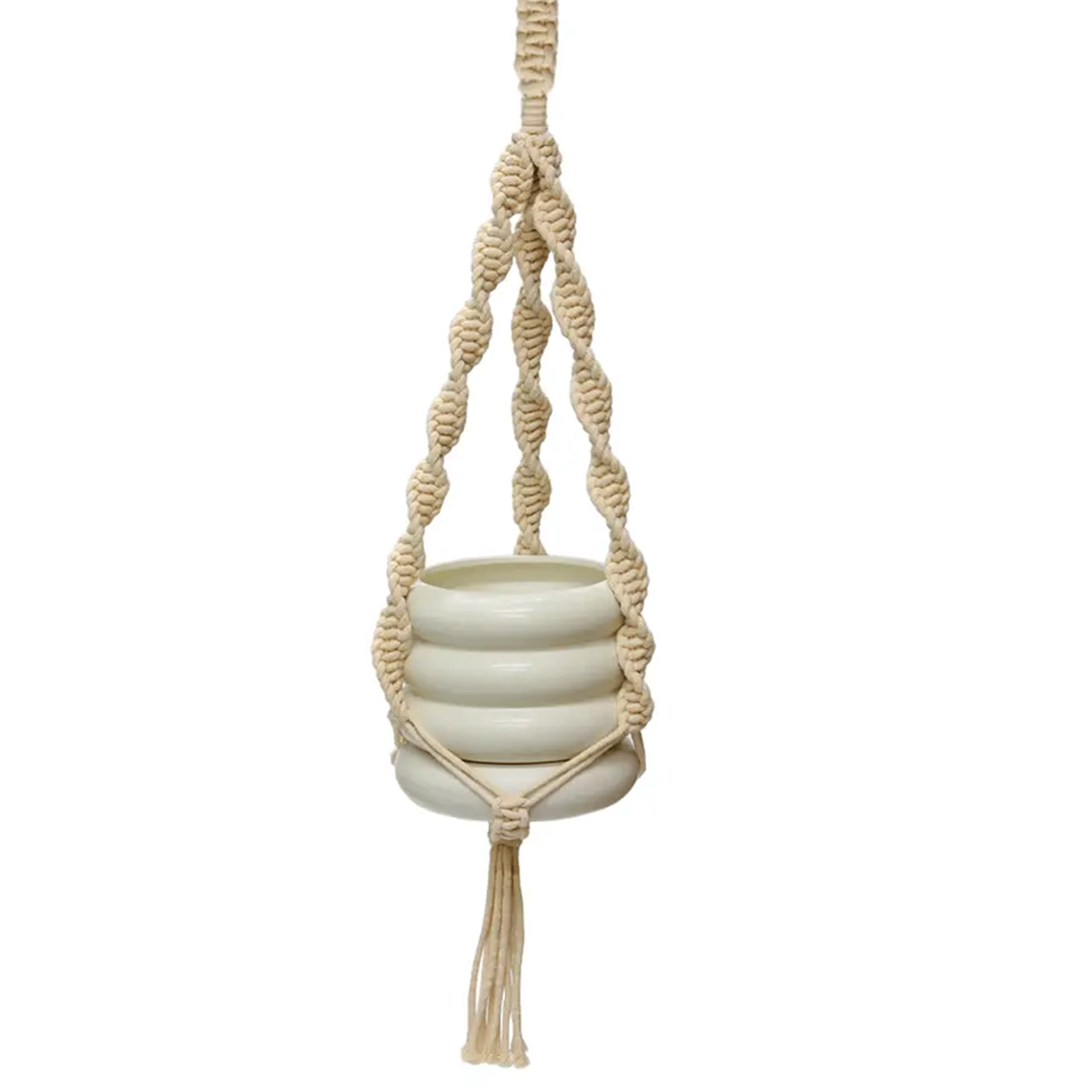 On a white background is a woven natural macrame plant hanger with a ceramic planter inside, not included with purchase. The macrame hanger has a twisted detail and a tassel bottom. 