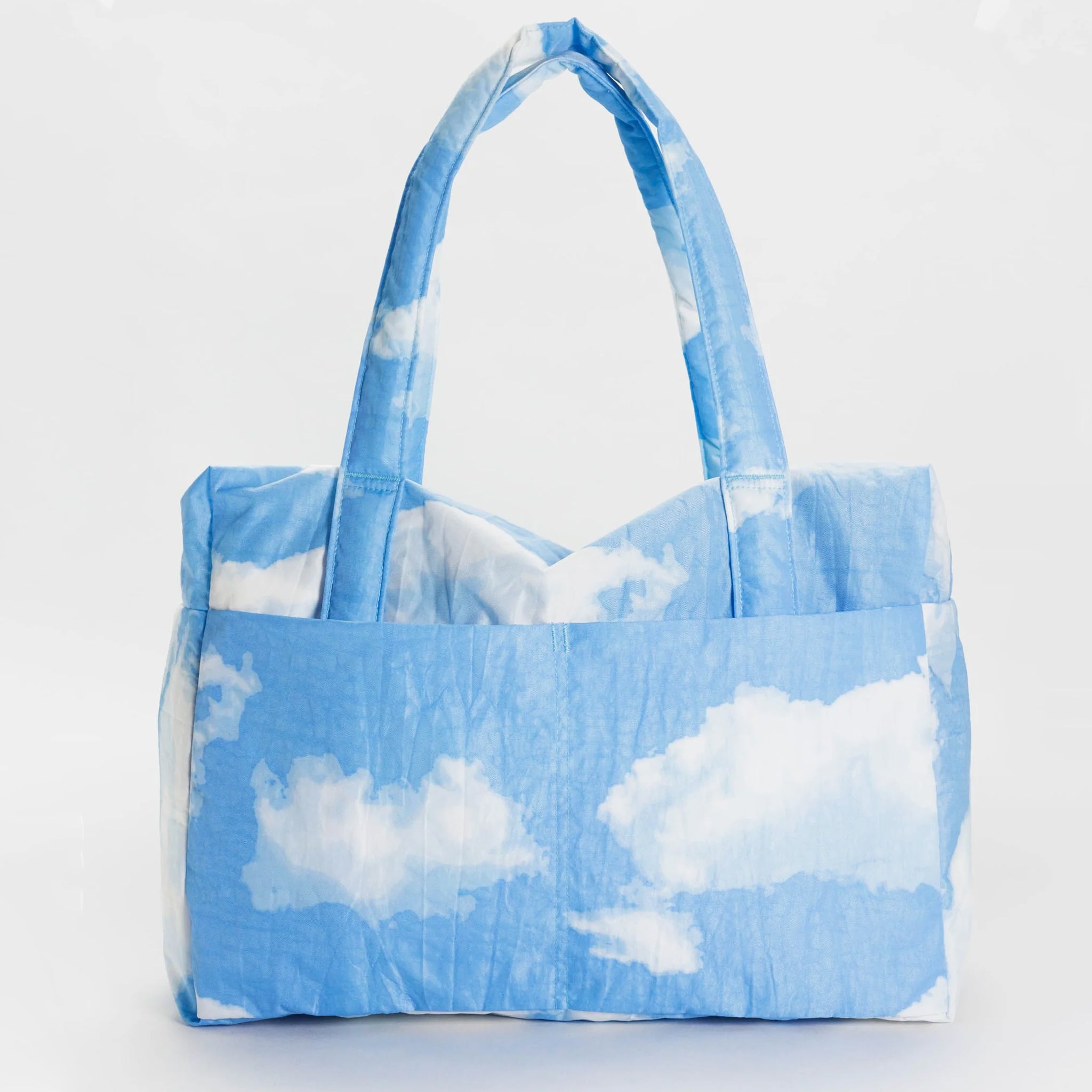 A puffer material bag with a blue and white cloud print. 