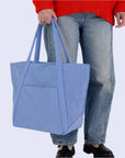 A blue nylon tote bag with two handle straps and a front pocket.