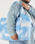 A puffer material bag with a blue and white cloud print.