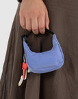 A mini blue crescent bag shaped bag charm with a zipper closure and a black loop for attaching.