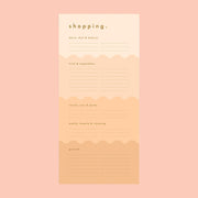 On a peachy background is a peachy wavy designed shopping notepad with gold foiled text details.