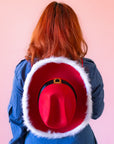 A cowboy hat with a "Santa Hat" design and a neck strap.
