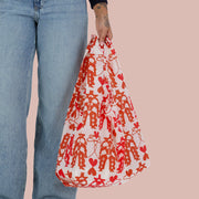 A red and light pink nylon tote bag with a cowgirl print.