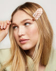 Two checkered hair clips with a white and pinkish terracotta checker print.