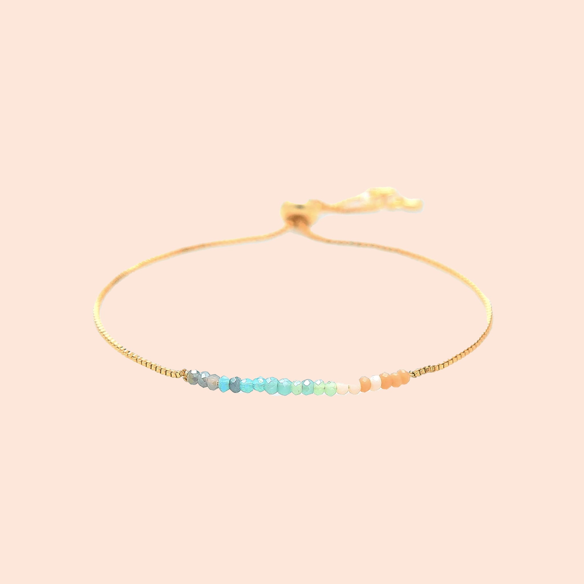 A gold bracelet with multicolored beads. 