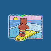 A graphic of a bobbie goods bear on a surf board with the sunset in the background.